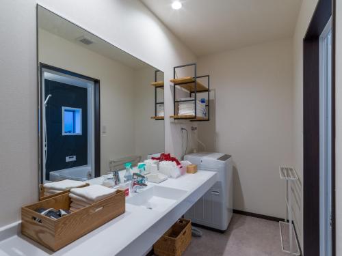 Un baño con lavabo y un espejo grande. en Rakuten STAY HOUSE x WILL STYLE Sasebo 106, en Sasebo