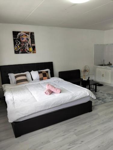 a bedroom with a large bed with pink towels on it at อิมแพ็ค popular condo c5 แม่ตังค์ in Ban Bang Phang