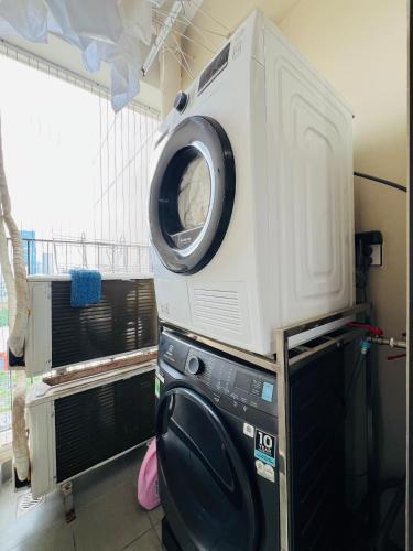 a microwave sitting on top of a washing machine at HN ETH Vinhomes D'capitale Resident - Tran Duy Hung St in Hanoi