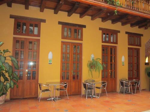 a room with tables and chairs and a yellow wall at Casa India Catalina in Cartagena de Indias