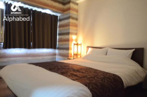ein Schlafzimmer mit einem großen weißen Bett und einem Fenster in der Unterkunft Alphabed Takamatsu Kitahama EAST 203 / Vacation STAY 20107 in Takamatsu