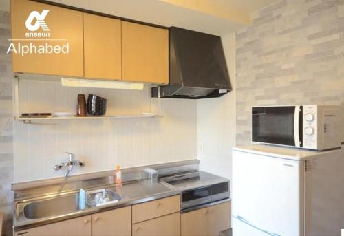 a kitchen with a sink and a microwave and a refrigerator at Alphabed Takamatsu Kitahama EAST 202 / Vacation STAY 20102 in Takamatsu