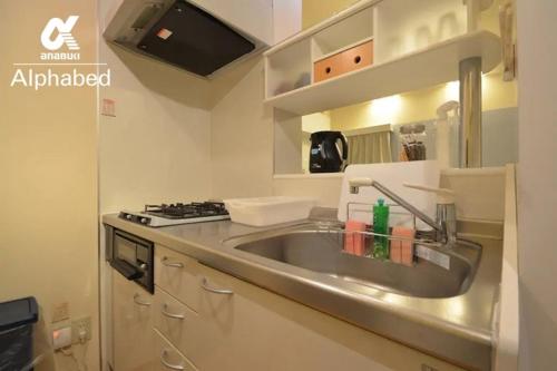 une cuisine avec un évier et une cuisinière dans l'établissement Alphabed TakamatsuKawaramachi WEST 702 / Vacation STAY 21599, à Takamatsu