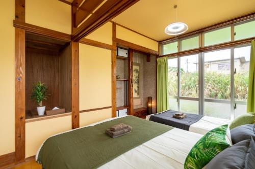 a bedroom with two beds and a large window at Uruma - House / Vacation STAY 19738 in Teruma