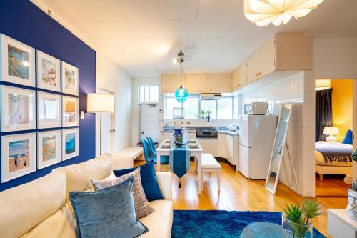 a living room with a white couch and a blue wall at Uruma - House / Vacation STAY 19738 in Teruma