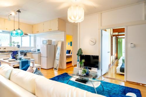 a living room with a white couch and a blue rug at Uruma - House / Vacation STAY 19738 in Teruma