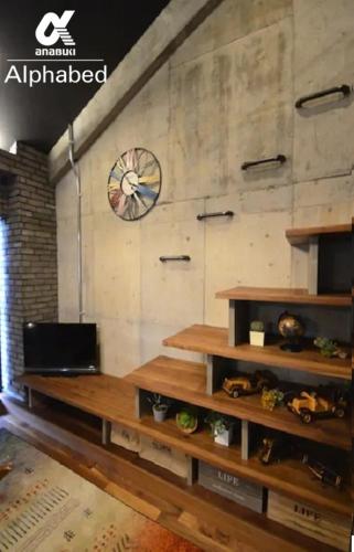 a room with wooden shelves and a clock on a wall at Alphabed SunportTakamatsu 701 / Vacation STAY 21860 in Takamatsu