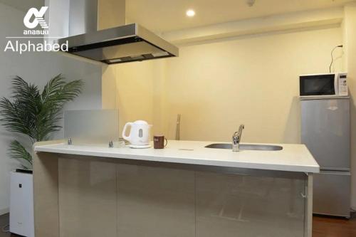 a kitchen with a sink and a microwave at Alphabed TakamatsuFurujinmachi 901 / Vacation STAY 21909 in Takamatsu