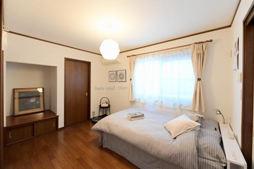 a bedroom with a bed and a tv and a window at Nerima-ku - House / Vacation STAY 3889 in Tokyo