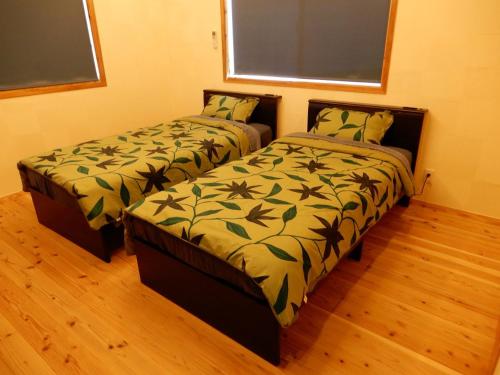 two beds sitting next to each other in a bedroom at Uruma - House - Vacation STAY 16594 in Uruma