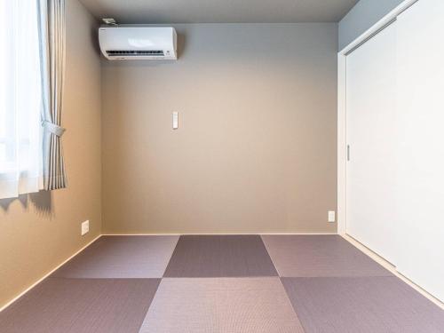 an empty room with a door and a checkerboard floor at Rakuten STAY HOUSE x WILL STYLE Takasaki 104 in Takasaki