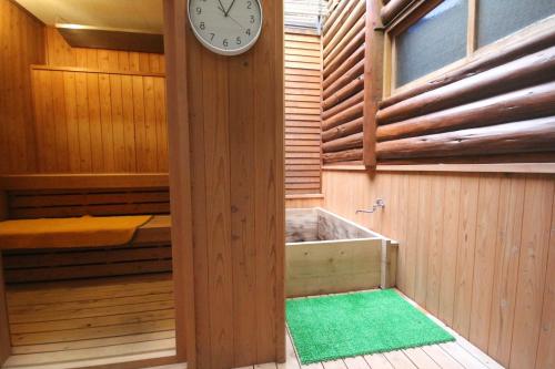 a clock on a wall next to a bath tub at Takaoka-gun - Bungalow / Vacation STAY 33199 in Funato