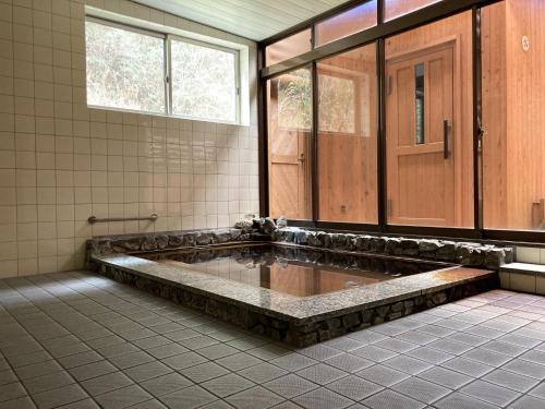 a large bathroom with a hot tub in the middle at Nature Resort in Shimanto / Vacation STAY 33197 in Funato