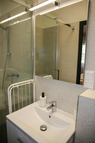 a bathroom with a sink and a large mirror at AKZ Apartman in Makó