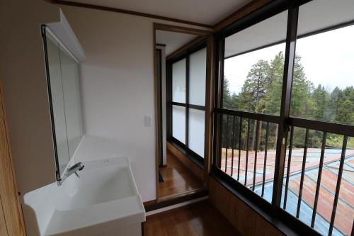 a bathroom with a white sink and large windows at Nakatsugawa - House / Vacation STAY 39303 in Nakatsugawa
