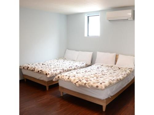 two beds sitting next to each other in a room at Yokocho Building / Vacation STAY 42628 in Beppu