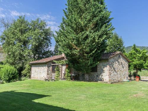 a stone house in a field with a tree at Spacious holiday home in Ambra