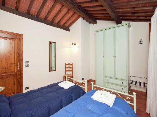 a bedroom with two beds and a glass cabinet at Spacious holiday home in Ambra