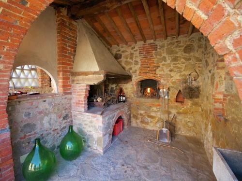 a stone kitchen with a stone oven with green vases at Spacious holiday home in Ambra