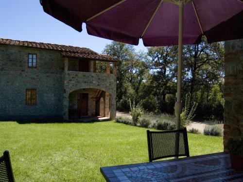 a table and chairs with an umbrella in a yard at Spacious holiday home in Ambra