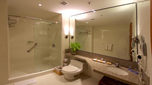 a bathroom with a toilet and a shower and a sink at GHL Hotel Grand Villavicencio in Villavicencio