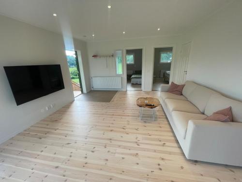 FärgelandaにあるApartment on a farm with lake viewの白いソファと薄型テレビのあるリビングルーム