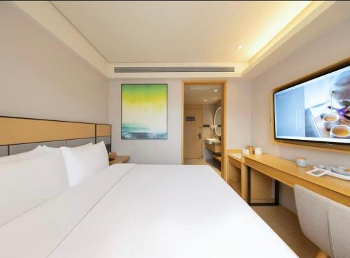 a hotel room with a large bed and a flat screen tv at 全季北京南站角门东地铁站酒店 in Beijing