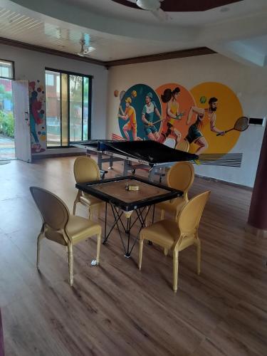 a room with a ping pong table and chairs at Sandalwoods Resort in Neral