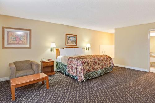 um quarto de hotel com uma cama e uma cadeira em Americas Best Value Inn & Suites La Porte/Houston em La Porte