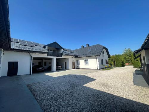 una grande casa bianca con un vialetto d'accesso di Willa Apartament Prestige z sauną i siłownią na wyłączność a Żołynia