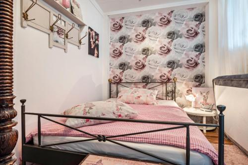 a bedroom with a bed with a wallpaper of roses at Kleine Oase Stuhr im Container E G 