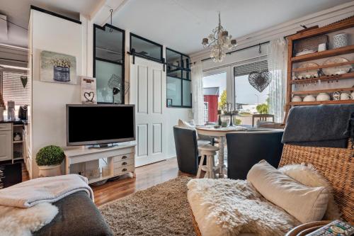 a living room with a television and a dining room at Kleine Oase Stuhr im Container E G 