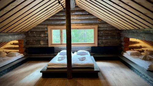 a room with two beds in a log cabin at Kelokurki - The Luxury Lodge Where Serenity Meets the Northern Lights in Levi