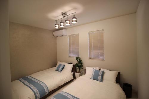 two beds in a room with two windows at HOPE VILLA Onna-son - Vacation STAY 52856 in Inbu