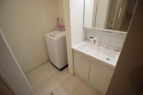 a bathroom with a sink and a washing machine at HOPE VILLA Onna-son - Vacation STAY 52856 in Inbu
