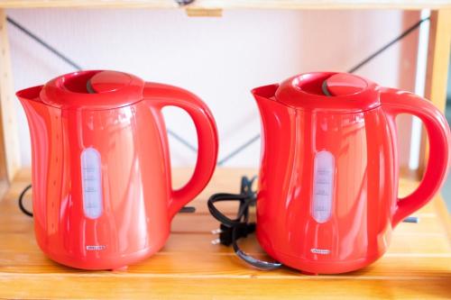 two red vases sitting on top of a wooden table at Harbors - Vacation STAY 54826 in Beppu