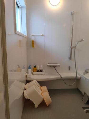 a white bathroom with a shower and a sink at Ikuta / Vacation STAY 53359 in Haneda