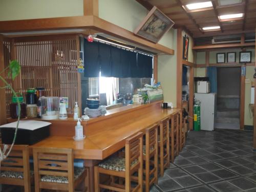 a kitchen with a bar with wooden tables and chairs at Ikuta / Vacation STAY 53359 in Haneda