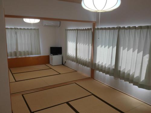an empty room with white curtains and a television at Ikuta / Vacation STAY 53359 in Haneda