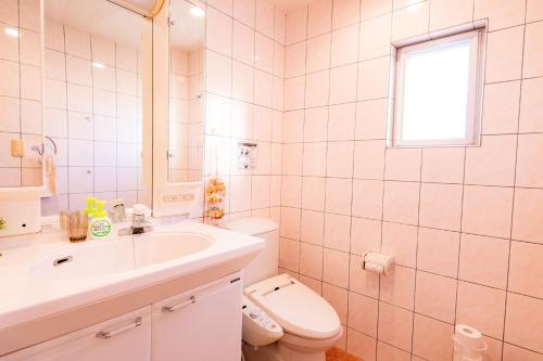 a white bathroom with a sink and a toilet at Kunigami-gun - House / Vacation STAY 53153 in Atsutabaru