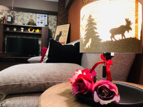 a lamp sitting on a table with a rose on a table sidx sidx at Mori building / Vacation STAY 49788 in Takamatsu