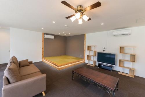 a living room with a couch and a flat screen tv at Tancha Detached house / Vacation STAY 50245 in Motobu