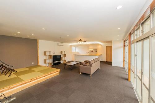 a large room with a bed and a couch at Tancha Detached house / Vacation STAY 50245 in Motobu