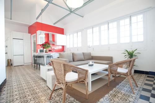 sala de estar con sofá, mesa y sillas en Apartamentos Calle Rosario, en Sevilla
