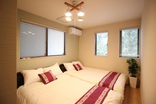 two beds in a room with windows at HOPE VILLA Onna-son - Vacation STAY 52848 in Inbu