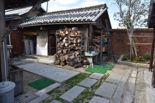 a house with a pile of logs in front of it at Kanakuraen / Vacation STAY 5125 in Marugame