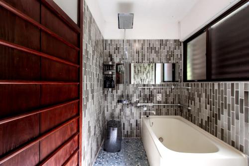 a bathroom with a tub and a tile wall at Oyado Ryu / Vacation STAY 54218 in Nagasaki