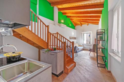 una cocina con paredes verdes y blancas y techos de madera. en Nido dell'Usignolo - Happy Rentals, en Riva del Garda