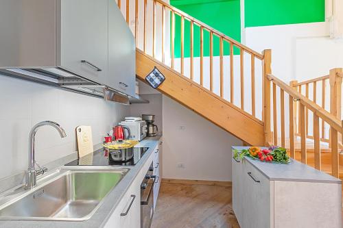 Una cocina con fregadero y escalera. en Nido dell'Usignolo - Happy Rentals, en Riva del Garda