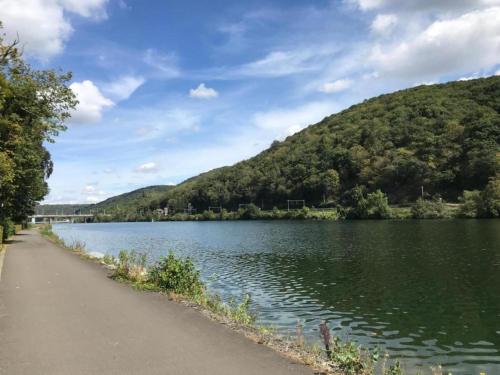a lake with a path next to a mountain at Cozy Chalet with barbecue in Trou du Diable